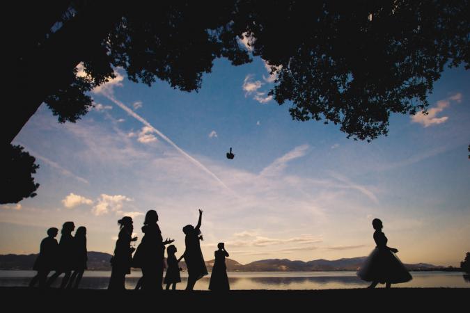 
	bouquet toss by the lake in Italy
