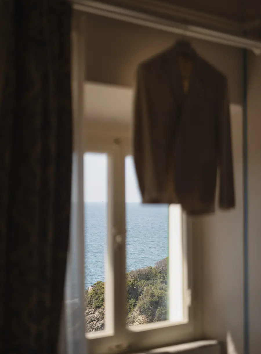 Groom's jacket hanging at the window with sea view, wedding preparations at Villa Parisi