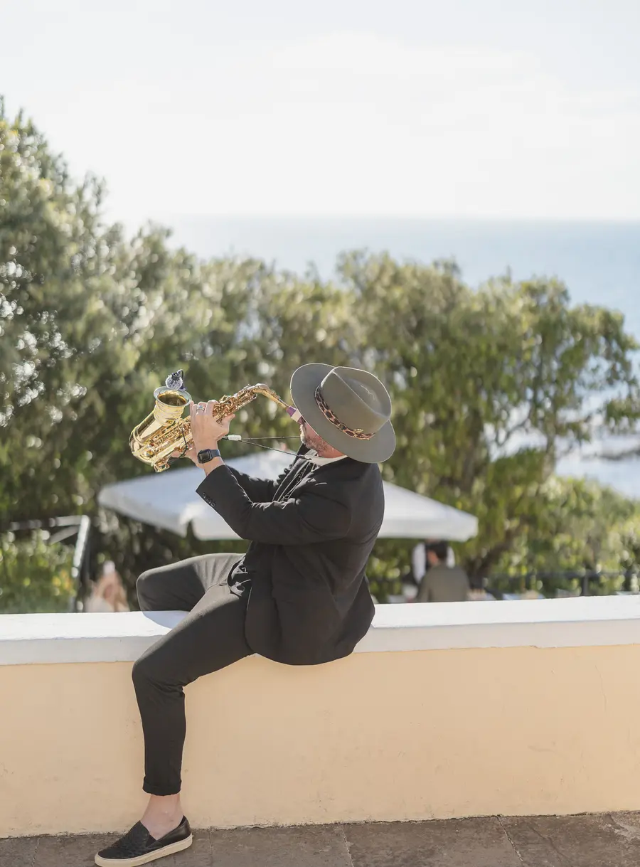 Saxophonist in a hat playing live at the seaside wedding in Castiglioncello