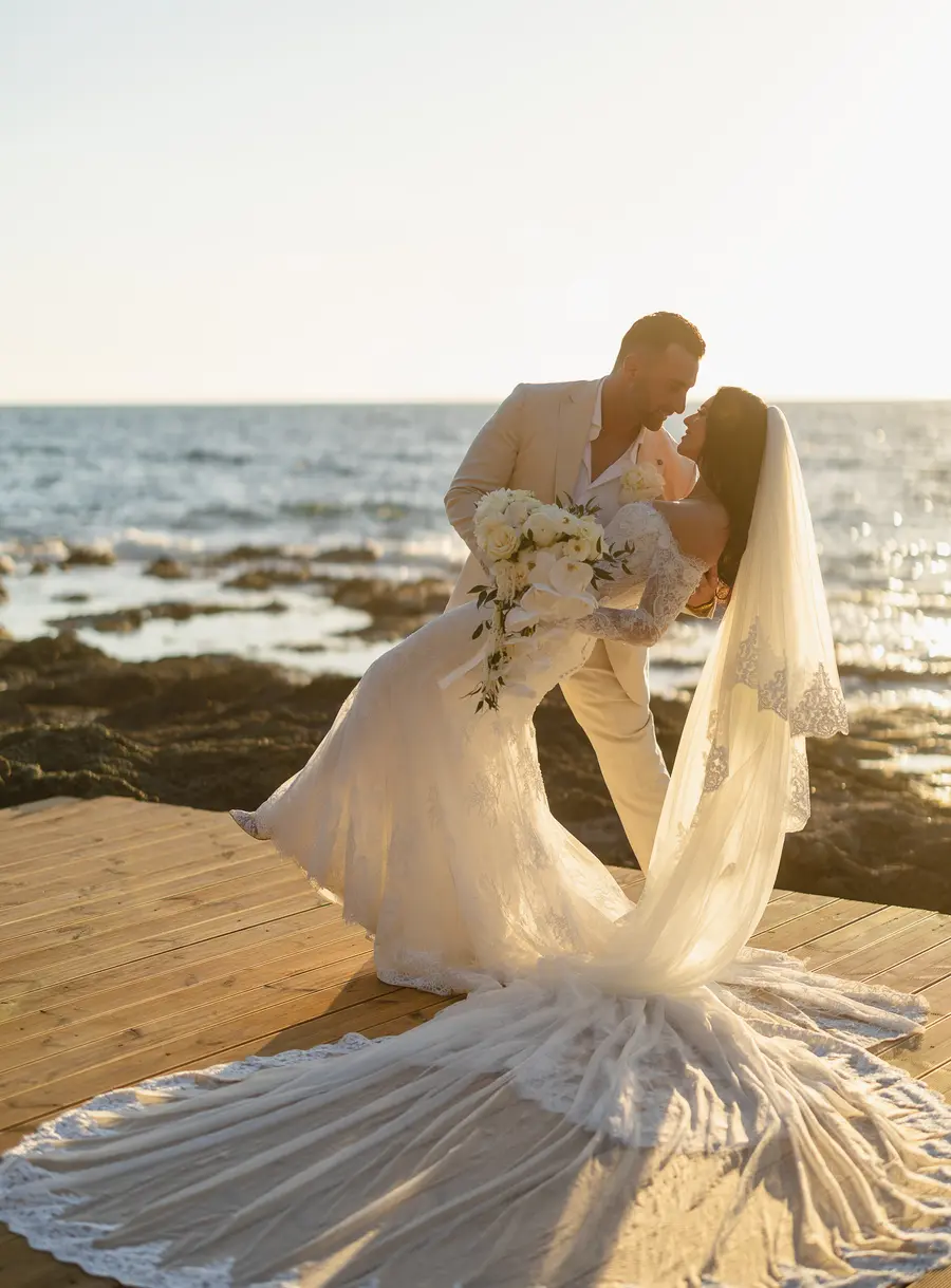 Romantic dip kiss at sunset on the wooden deck among the rocks