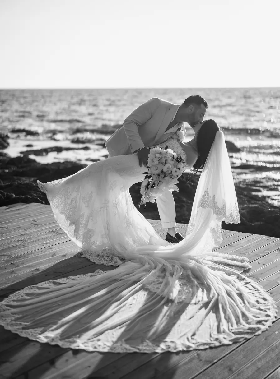 Black and white dip kiss on the wooden deck with the lace train fanned out