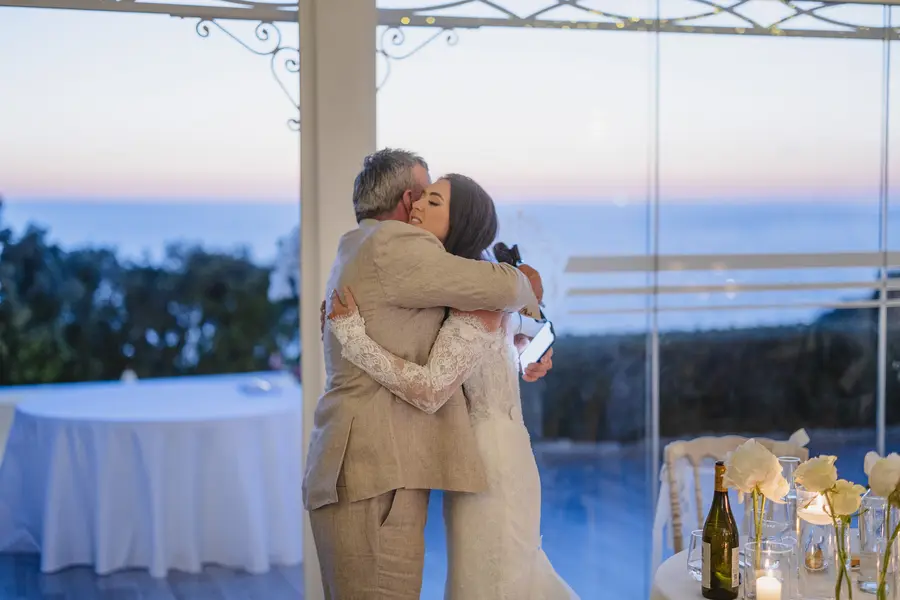 Emotional hug between the bride and a family member during the wedding dinner