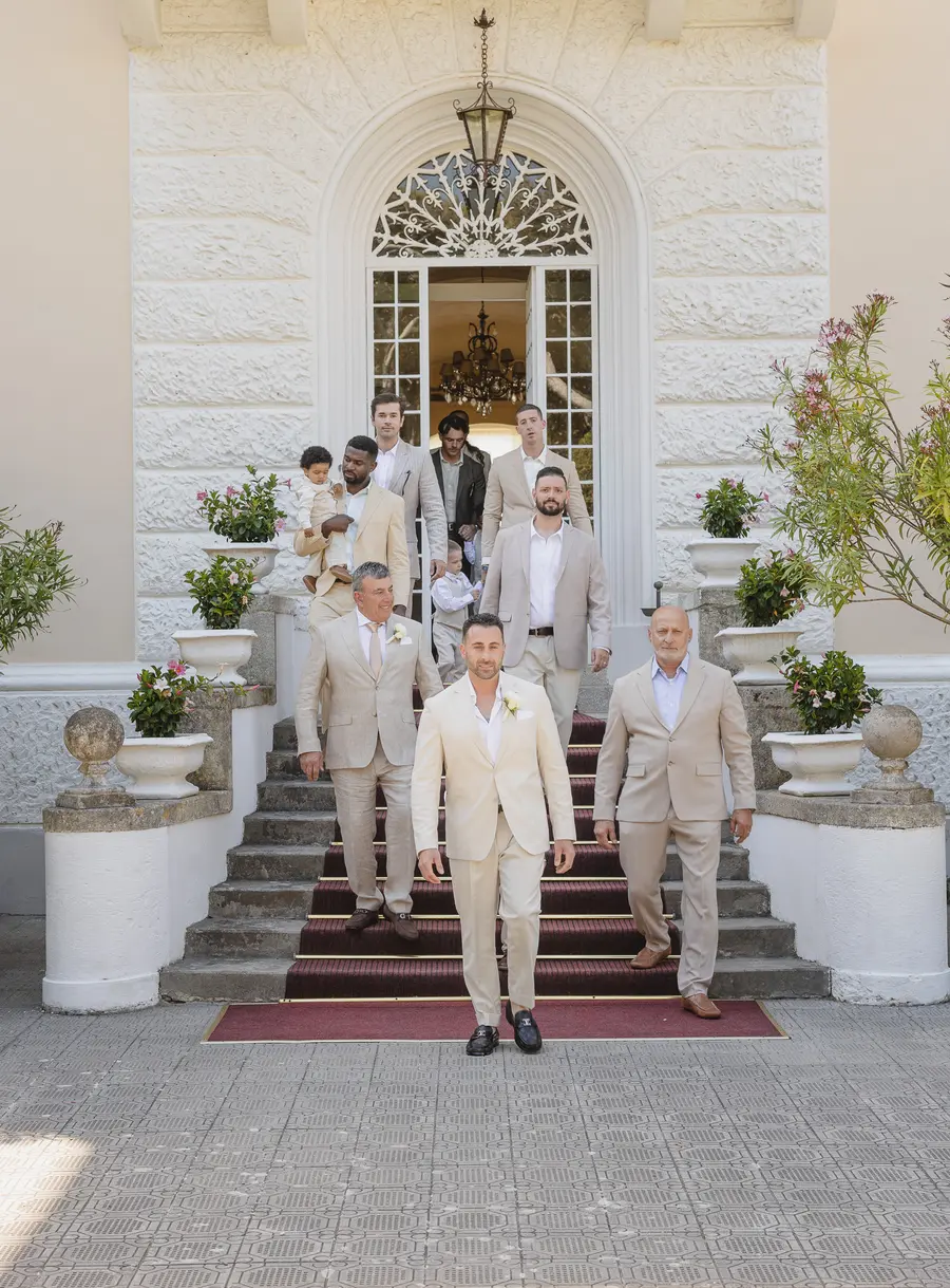 Groom walking down the Villa Parisi steps with friends and family to the ceremony