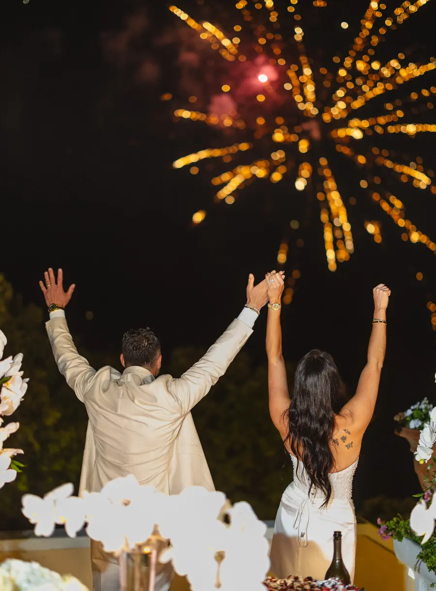 Frank and Nicolette from behind with raised arms under the fireworks at Villa Parisi
